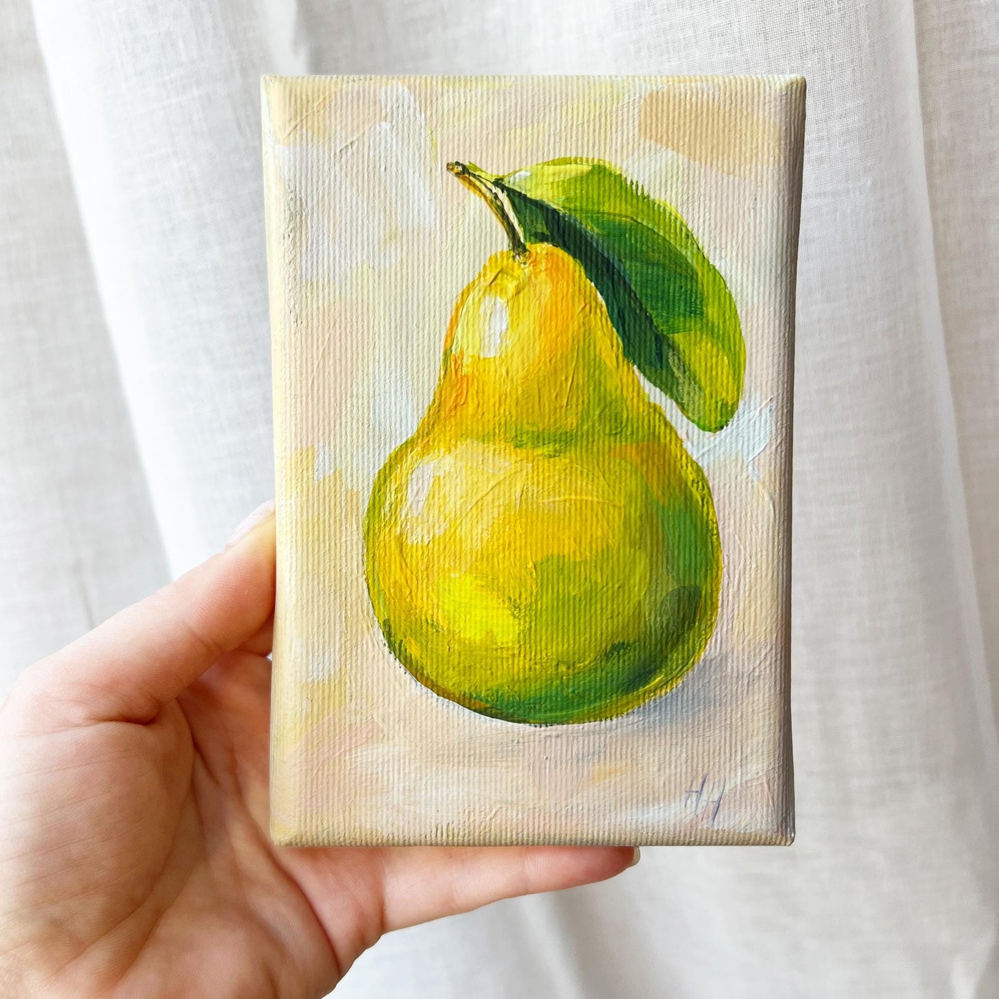 Original Yellow Pear oil painting by Hanna Hryharenka shown in kitchen setting with complementary decor