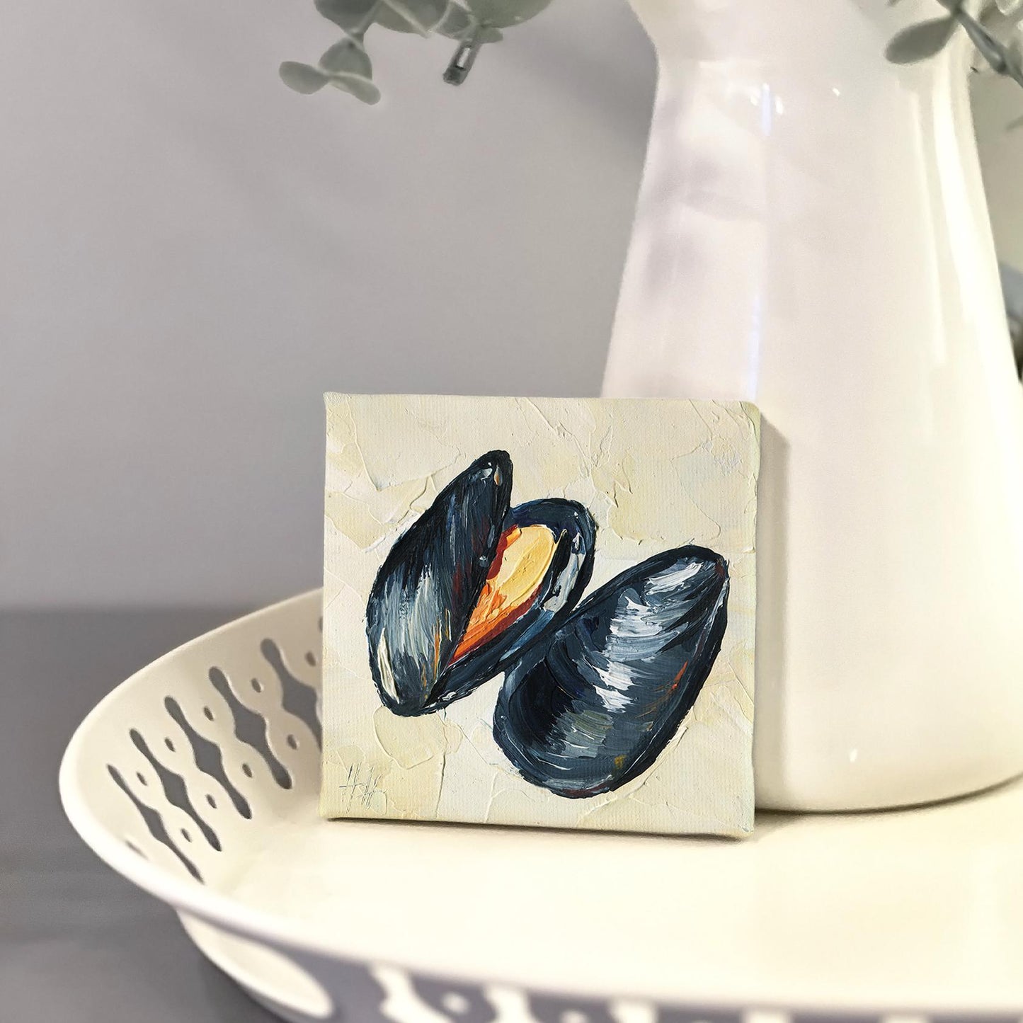 Mussel oil painting by Hanna Hryharenka displayed in kitchen setting, showing how the small 4x4 inch coastal artwork adds sophisticated elegance to culinary spaces and beach house decor