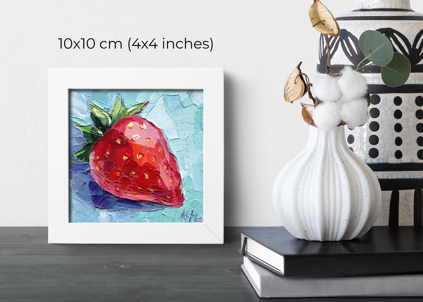 Close-up view of mini strawberry canvas painting by Hanna Art showing rich impasto texture and dimensional quality, featuring bright red fruit with green stem against blue background, handmade 4x4 inch original artwork