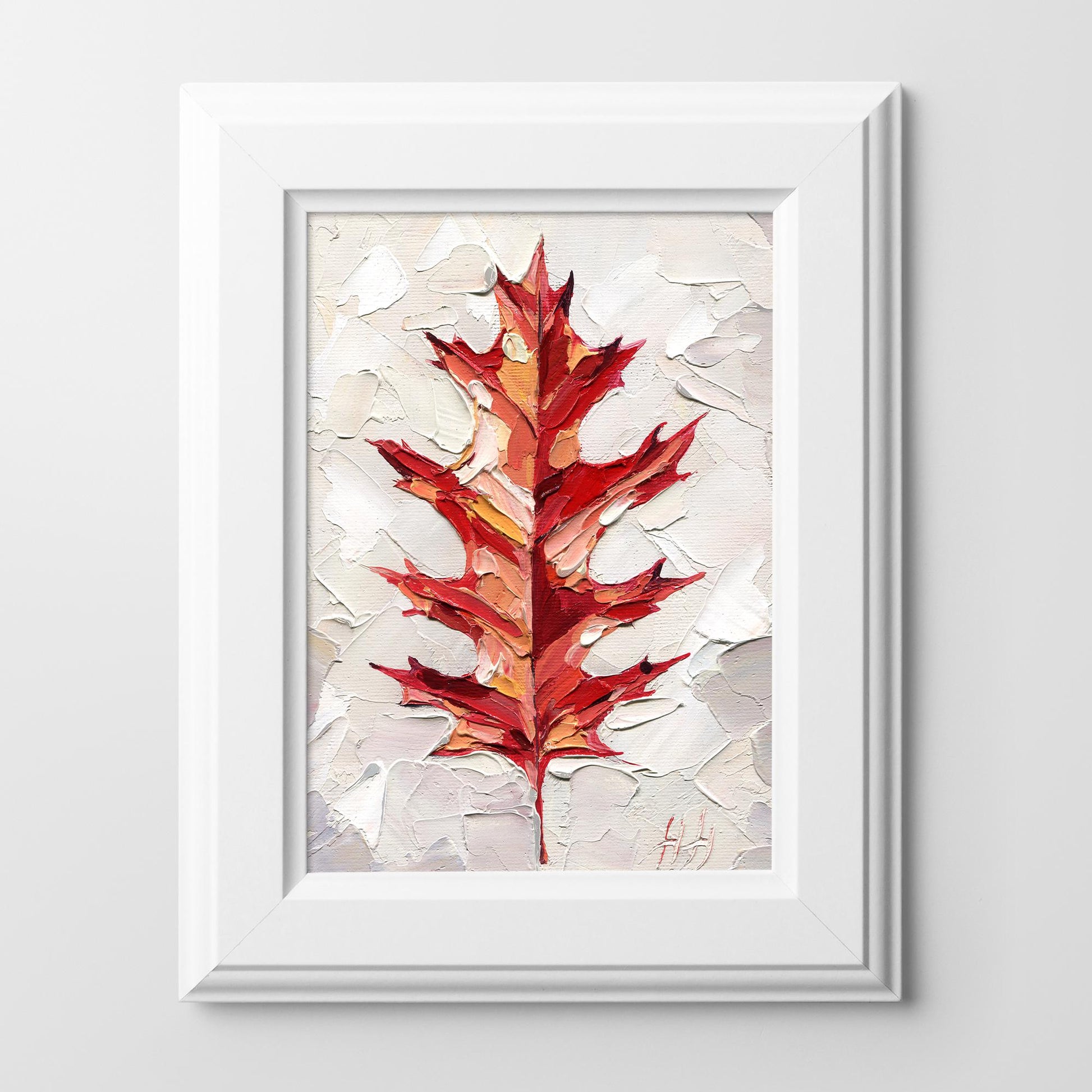 Framed artwork of a red maple leaf on a textured beige background