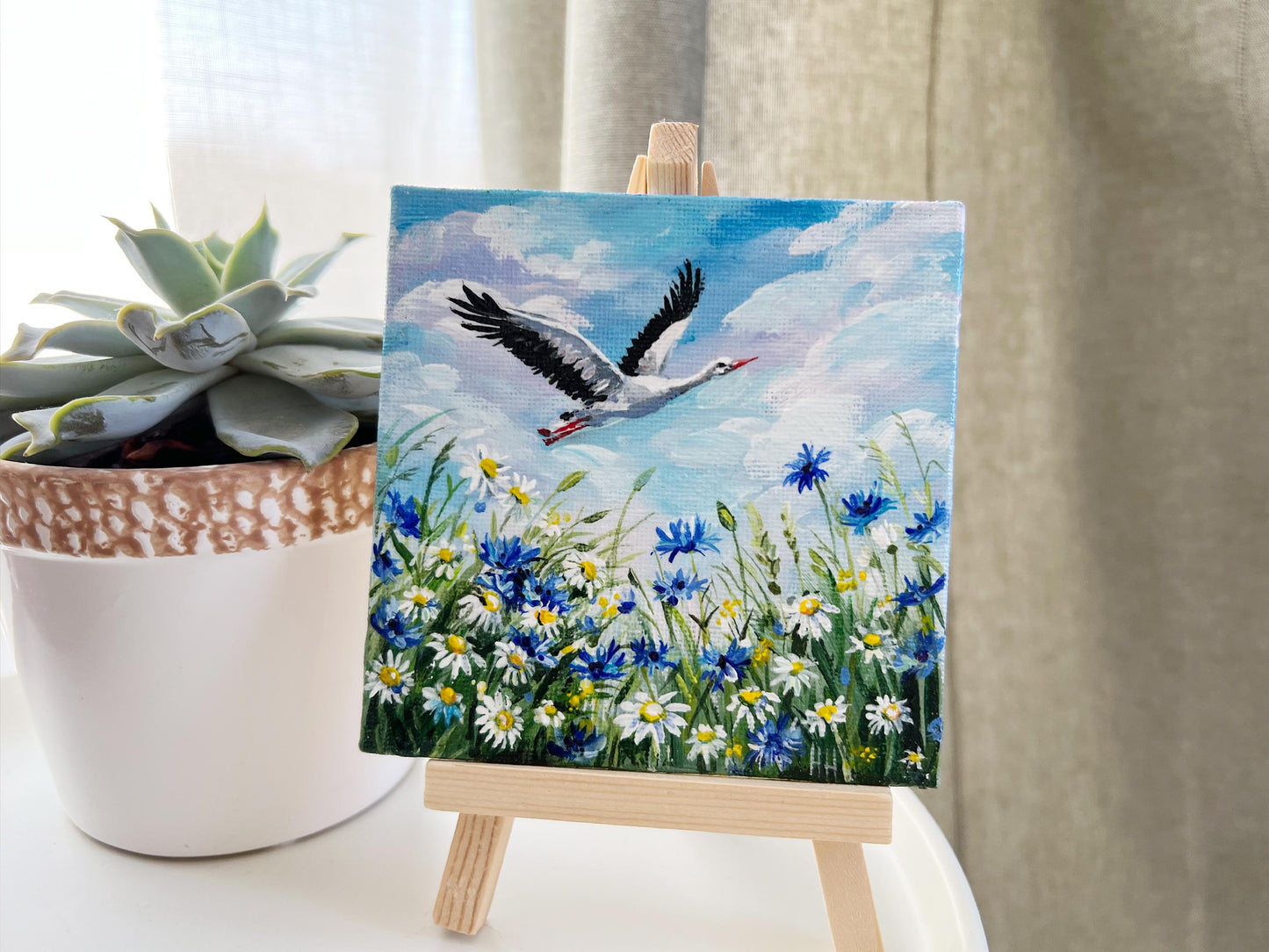 Stork flies over blooming field of daisies and cornflowers. Hand-Painted Mini Canvas Wildflower Meadow Art. Bird Lover Gift Original Artwork