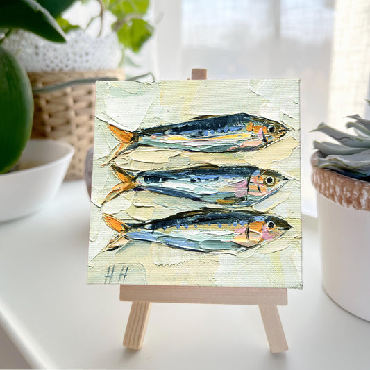 Sardine oil painting by Hanna Hryharenka displayed in kitchen setting, showing how the small 4x4 inch coastal artwork adds seaside charm to culinary spaces and French home decor