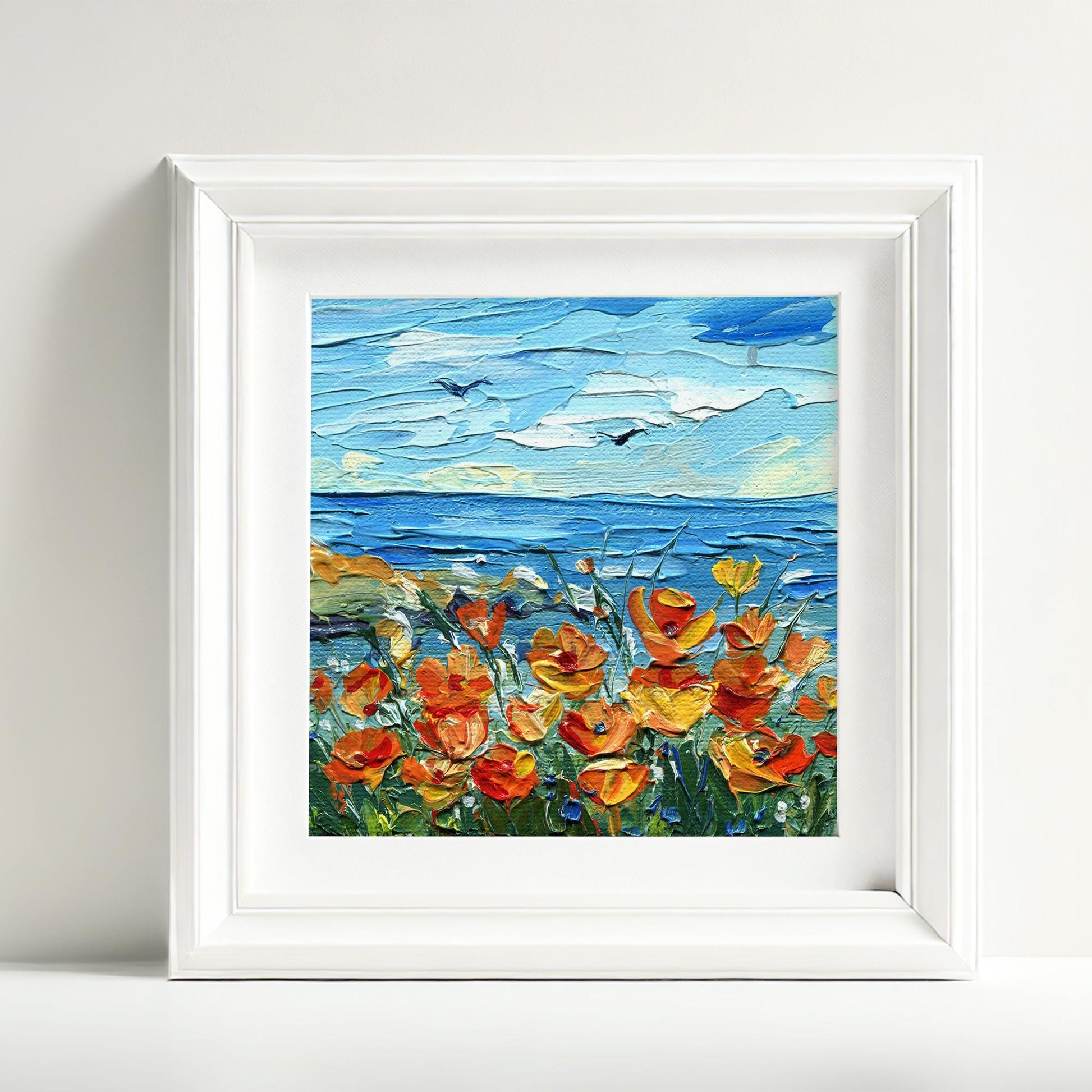Handcrafted 4x4 inch California poppy artwork by Hanna Hryharenka showcasing brilliant amber wildflowers near the shoreline with thick textured paint application under azure skies, ideal for seaside botanical wall art by Hanna Art