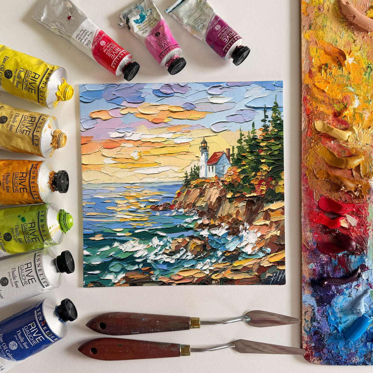 Acadia Lighthouse original oil painting displayed with paint tubes and palette knives